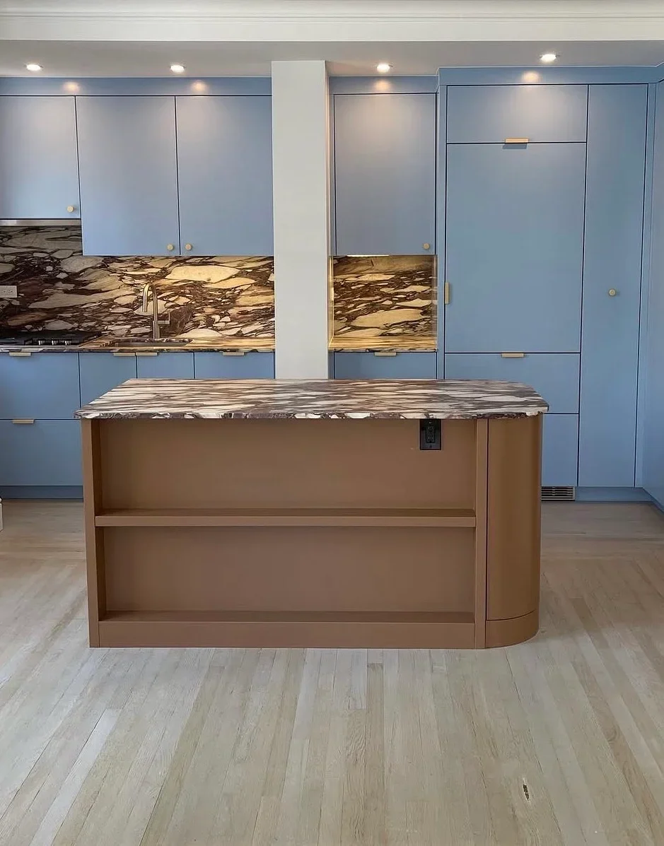 Modern kitchen with blue cabinetry, marble backsplash, and custom wood island