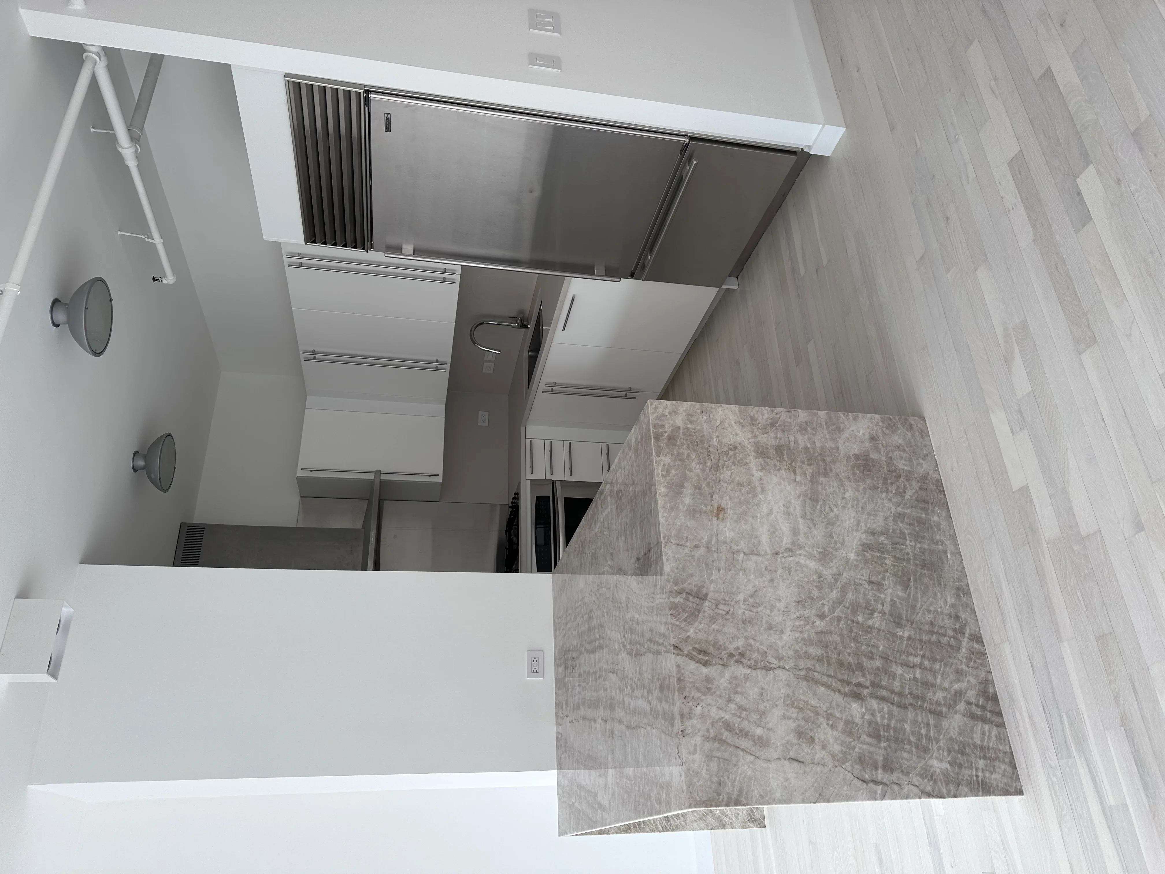 Modern bathroom with gray tile flooring, white walls, recessed lighting, and chrome fixtures
