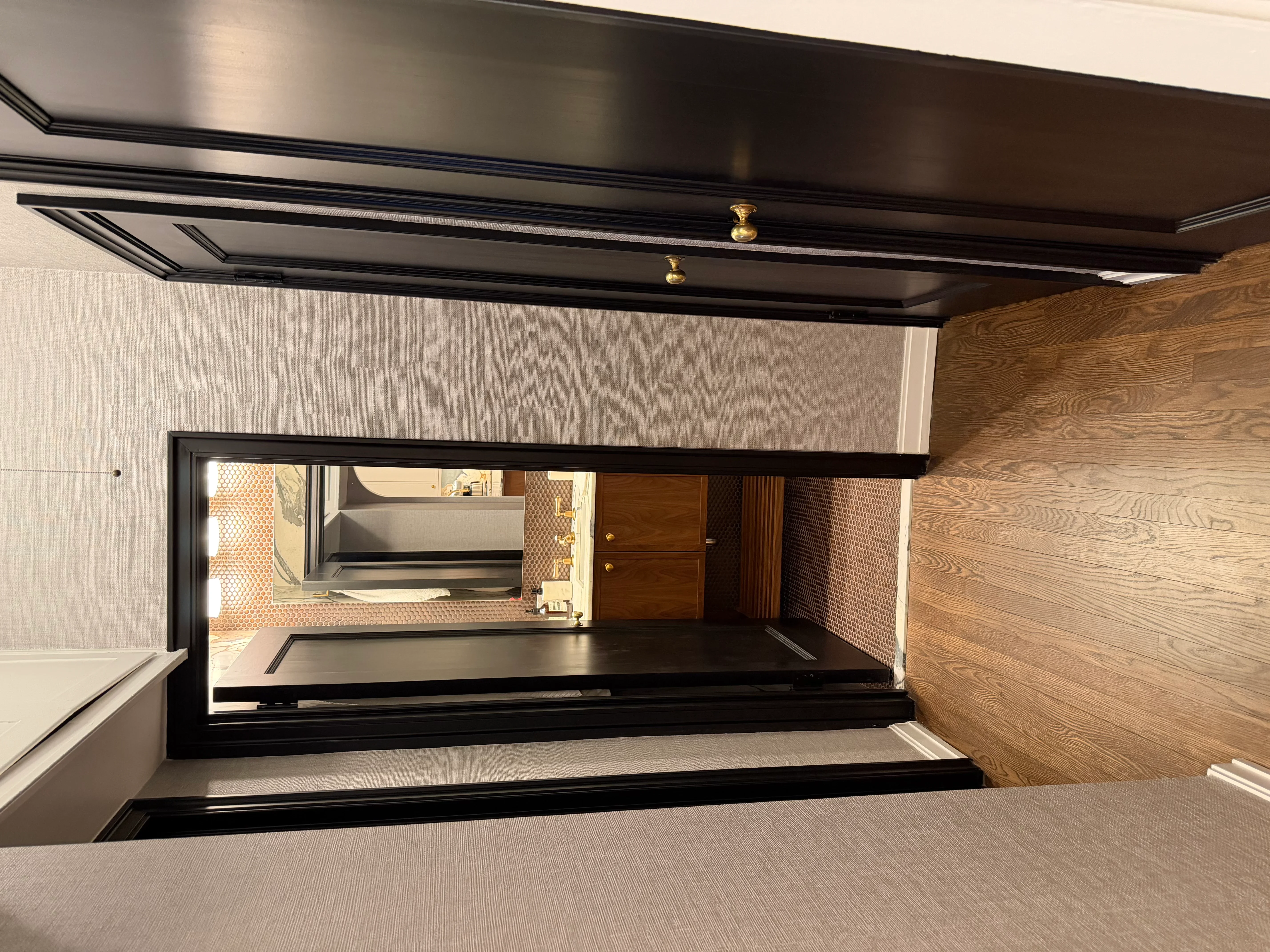 Modern kitchen with oak cabinetry, black metal frames, and brick tile backsplash