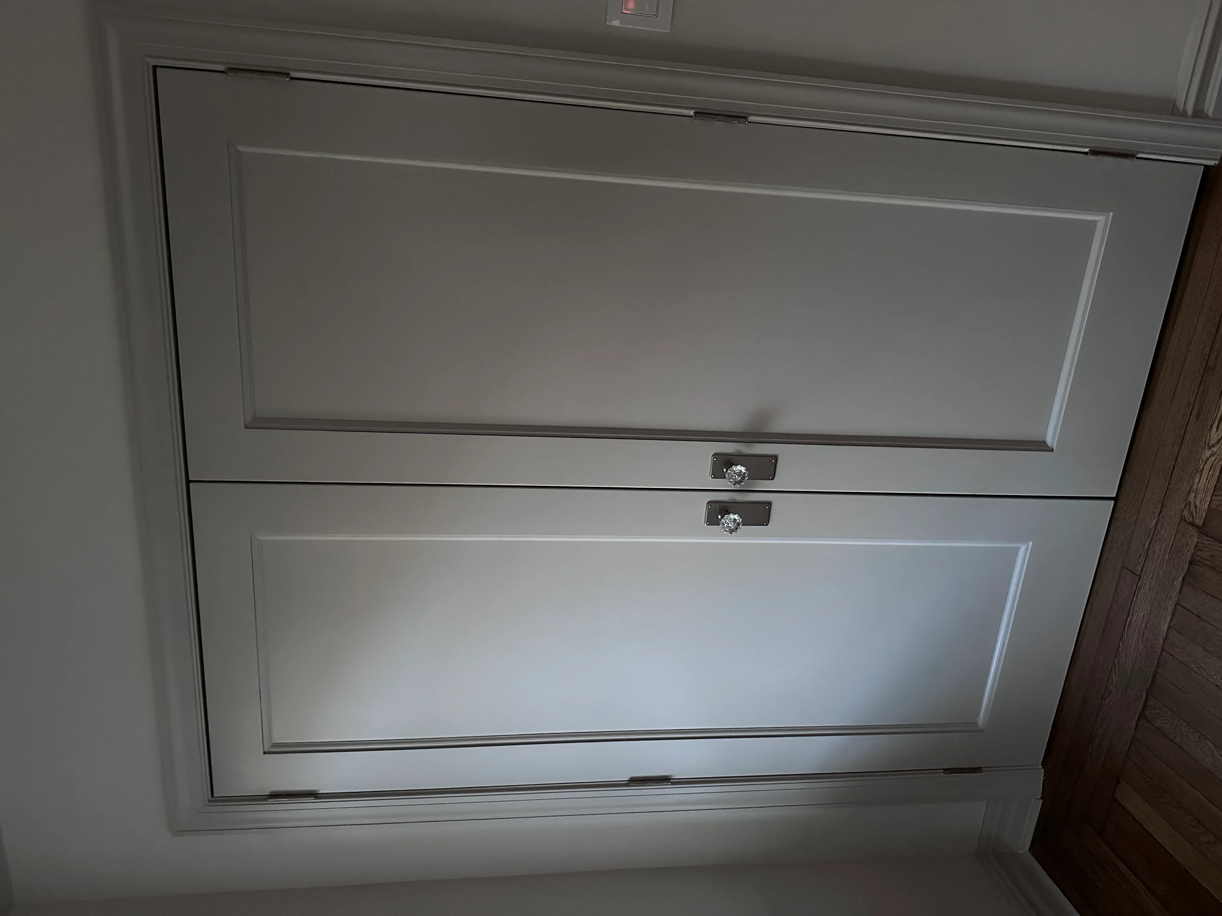 White two-panel garage door with recessed panels and chrome handles installed in Lynbrook home